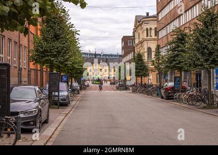 Belle vue sur le paysage de la ville le jour de l'automne. Vieux bâtiments colorés, voitures garées et vélos, homme sur la route de passage à vélo. Suède. Uppsala. Banque D'Images