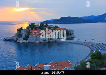 Vue panoramique sur le magnifique îlot (actuellement l'hôtel 5 étoiles Aman Sveti Stefan) de Sveti Stefan, Monténégro au coucher du soleil Banque D'Images