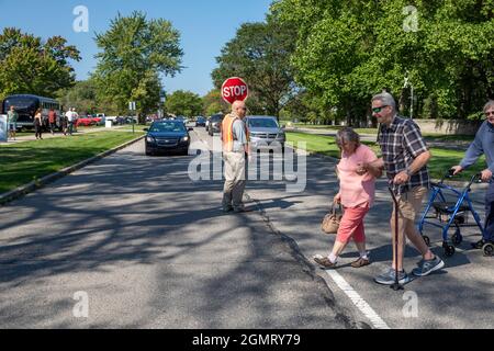 Grosse Pointe Shores, Michigan - Un garde-passage arrête la circulation pour les piétons qui assistent aux yeux du salon de l'auto Design au Edsel & Eleanor Ford Hou Banque D'Images