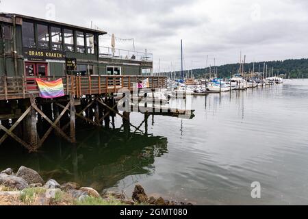 Restaurant sur le quai à côté de la marina avec les Voiliers en un jour nuageux Banque D'Images