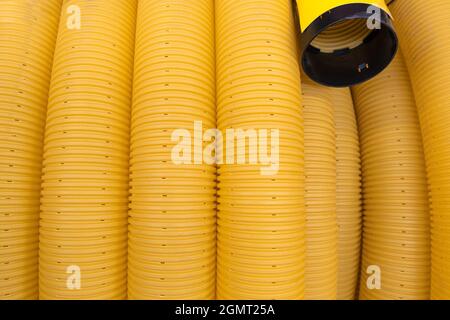 Tuyau flexible de drainage terrestre à bobine jaune fendu perforé. Gros plan Banque D'Images