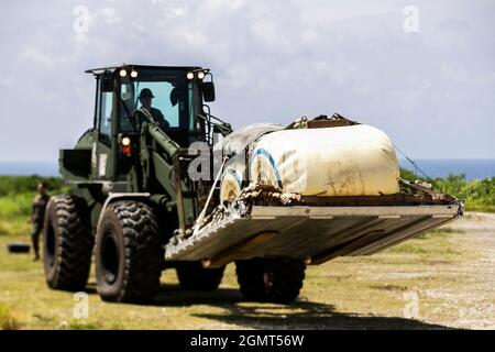 Un opérateur américain d'équipement lourd Marine avec 3d Landing support Battalion, combat Logistics Regiment 3, 3d Marine Logistics Group, se prépare à charger des engins sur un C-130 lors d'un exercice de livraison aérienne sur l'île de Shima IE, Okinawa, Japon, le 15 septembre 2021. Marines avec Marine Aerial Refueler transport 152, Marine Aircraft Group 12, 1st Marine Air Wing, et 3d LSB, 3d MLG, a dirigé la livraison d'air de sang et de fournitures médicales, et a conduit la ligne statique et les sauts de chute libre au-dessus de IE Shima île. le mlg 3d, basé à Okinawa, au Japon, est une unité de combat déployée en avant qui sert d’ensemble du MEF III Banque D'Images