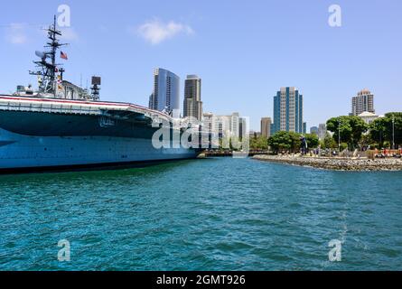 Le porte-avions historique USS Midway, aujourd'hui retiré comme musée au port, avec des bâtiments modernes de San Diego à proximité à San Diego, CA Banque D'Images