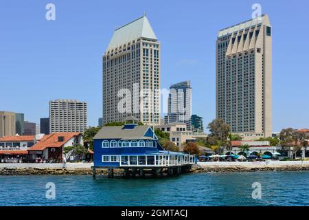 Le restaurant San Diego Pier, de style rétro bleu et blanc, est situé sur pilotis dans Seaport Village, avec des immeubles en hauteur sur la baie de San Diego, en Californie Banque D'Images