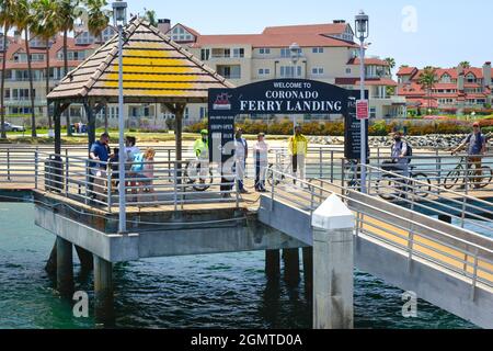 Les gens, certains à vélo, attendent à la jetée de chargement du ferry pour l'arrivée du bateau Coronado Ferry pour voyager à travers la baie de San Diego jusqu'à la jetée de San Diego Banque D'Images