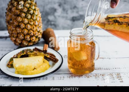 Tepache boisson mexicaine d'ananas fermenté et main tenant un pot avec kombucha maison probiotique superfood tranché d'ananas dans la ville de Mexico Banque D'Images