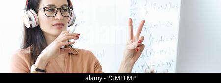 Portrait d'une femme enseignante dans un casque menant une leçon en ligne à distance Banque D'Images