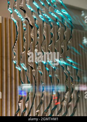 Des reflets, des motifs inscrits et un intérieur partiellement éclairé font de ces motifs abstraits fascinants dans une vitrine londonienne de nuit. Banque D'Images