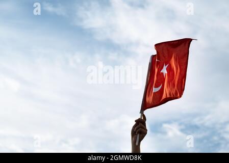 Gros plan sur un drapeau turc portatif qui agite sur un ciel nuageux et chaud. Banque D'Images