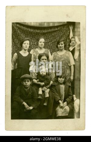 Carte postale originale du début des années 1920, portrait en plein air, toile de fond improvisée, mère de classe ouvrière, avec ses sœurs ou amis et enfants, personnages, Royaume-Uni Banque D'Images