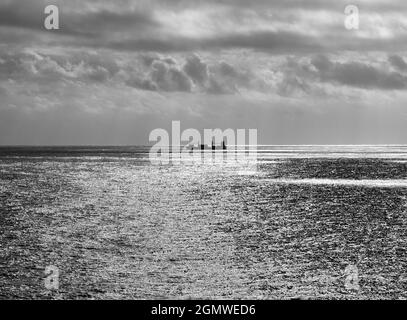 Un navire à conteneurs navigue en haute mer près de Stavanger, en Norvège. C'est une soirée en milieu d'été et, tard dans la journée, la mer est à l'eau avec le soleil bas. Banque D'Images