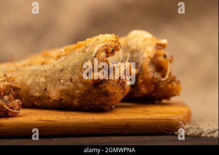 Petit poisson frit sur un panneau en bois, gros plan, sélectif Banque D'Images