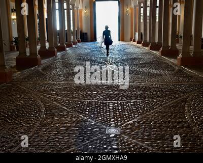 Séville, Anadalucia, Espagne - 31 mai 2016; une femme en vue, marchant loin et de retour à la caméra.J'aime la façon dont le soleil se déverse à travers l'entrée bo Banque D'Images