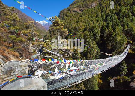 Pont suspendu en corde avec drapeaux de prière au Népal Himalaya sous Namche Bazar au-dessus de la rivière Dudh Koshi Nadi, randonnée du camp de base du mont Everest Banque D'Images