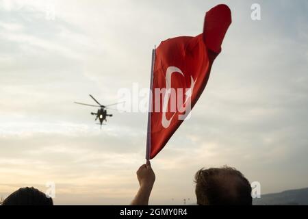 Izmir, Turquie - 9 septembre 2021 : hélicoptère de la police turque d'Atak et drapeau turc dans le même cadre lors des célébrations du jour de la libération d'Izmir Banque D'Images
