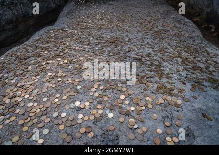 Pièces laissées par les touristes sur un lit de nuit dans le sanctuaire rupestre préhistorique de Beglik Tash situé sur la côte sud de la mer Noire en Bulgarie Banque D'Images