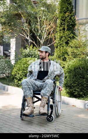 militaire handicapé en fauteuil roulant souriant tout en regardant dehors Banque D'Images