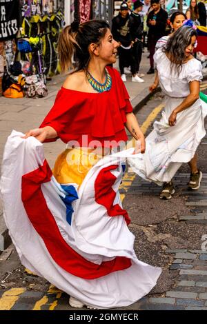 Les femmes colombiennes dansant dans une rue au large de Brick Lane dans le cadre D'une protestation contre le gouvernement colombien, Londres, Royaume-Uni. Banque D'Images