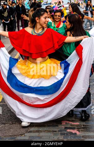 Les femmes colombiennes dansant dans une rue au large de Brick Lane dans le cadre D'une protestation contre le gouvernement colombien, Londres, Royaume-Uni. Banque D'Images