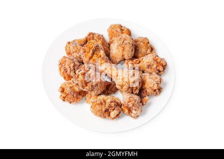 Restauration rapide, nourriture de qualité.ailes de poulet semi-cuites surgelées sur une assiette blanche sur fond blanc. Banque D'Images