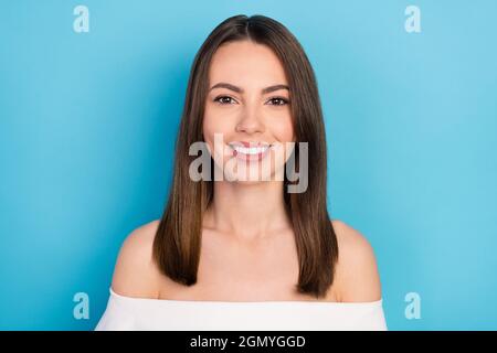 Photo de la brunette optimiste femme millénaire porter le haut blanc isolé sur fond bleu Banque D'Images