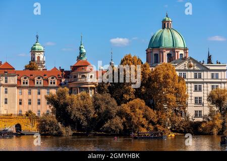Rivière Vltava, arbres et coupole de l'église Saint François d'Assise sous ciel bleu dans la vieille ville de Prague, République tchèque. Banque D'Images