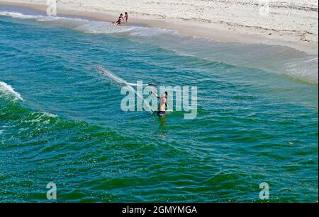 RIO DE JANEIRO, BRÉSIL - 25 MARS 2017 : pêche d'homme avec filet dans l'eau de la plage de Barra da Tijuca Banque D'Images