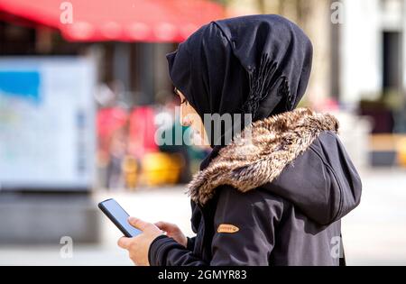 Dundee, Tayside, Écosse, Royaume-Uni. 21e. Septembre 2021. Météo au Royaume-Uni : une journée ensoleillée avec une brise fraîche et forte à travers le nord-est de l'Écosse, des températures atteignant 17°C. Une femme musulmane passe la journée à profiter du temps frais et ensoleillé tout en envoyant des SMS sur son téléphone mobile dans le centre-ville de Dundee. Crédit : Dundee Photographics/Alamy Live News Banque D'Images