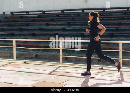 Une femme de sport et un casque court sur un tapis roulant Banque D'Images