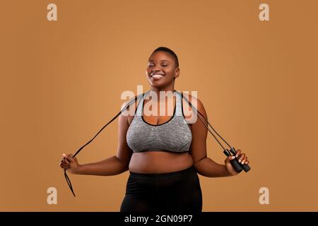 Black Chubby femme posant avec corde de saut au Studio Banque D'Images