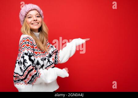 Photo en gros plan de positif heureux incroyable mignon joli charmant jeune femme tenant la main et montrant une publicité portant des vêtements décontractés isolé sur Banque D'Images