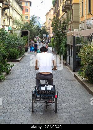 MILAN, ITALIE - 08 août 2021 : un garçon à vélo à trois roues dans une rue, Milan, Italie Banque D'Images