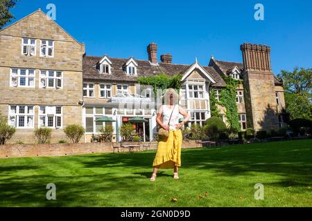 Femme à l'extérieur de l'hôtel Ockenden Manor à Cuckfield près de Haywards Heath , Sussex , Angleterre , Royaume-Uni Banque D'Images