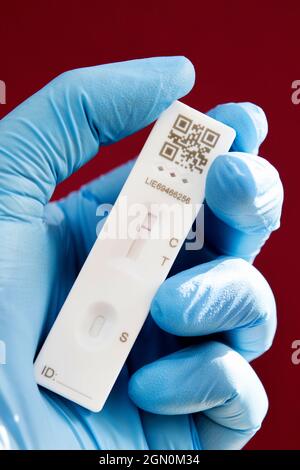 Gants médicaux bleus portant une bandelette de test de débit latéral à résultat négatif Covid 19 Banque D'Images