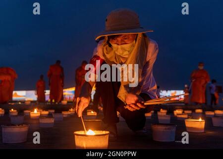 Patum Thani, Pathum Thani, Thaïlande. 21 septembre 2021. Wat Dhammakaya, connu pour sa construction unique de temple et sa doctrine spirituelle, a tenu une cérémonie pour marquer la Journée internationale de la paix, établie par les Nations Unies en 1981 comme un jour de cessez-le-feu et de non-violence. Le temple a organisé une exposition de plus de 200,000 bougies et lumières LED pour former des motifs visibles depuis le ciel représentant diverses étapes de la vie du maître de méditation tardif du temple, Luang pu Sodh Candasaro. Des milliers de personnes ont participé à distance à la cérémonie par appel zoom, avec leurs flux vidéo affichés sur l Banque D'Images