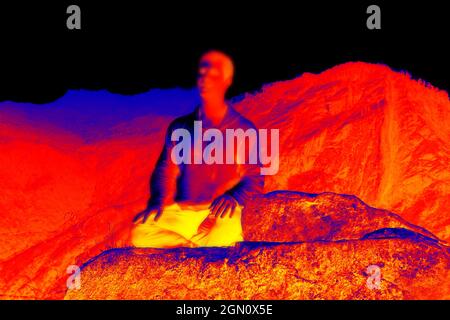 Pratique orientale (Yogi) sur fond de montagnes. Balayage de la température corporelle avec une caméra infrarouge. Sombre comcept de retraite (la méditation chang Banque D'Images