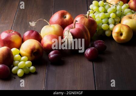 Des fruits frais mûrs d'automne se trouvent sur une surface en bois sombre Banque D'Images