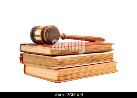 Le gavel d'un juge repose sur trois anciens livres de droit encadrés sur un fond blanc pour faciliter le placement de la copie. Banque D'Images