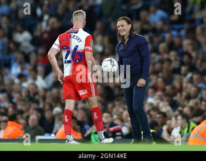 Gareth Ainsworth (à droite), gérant de Wycombe Wanderers, remet le ballon au joueur Jason McCarthy lors du troisième tour de la coupe Carabao au Etihad Stadium de Manchester. Date de la photo: Mardi 21 septembre 2021. Banque D'Images