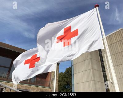 Deux drapeaux de la Croix-Rouge agitant dans le vent contre un ciel bleu. Gros plan. Copenhague, Danemark - 4 septembre 2021. Banque D'Images