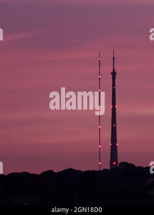 Station de transmission Emley Moor, à Wakefield, dans le West Yorkshire, silhoueted contre un coucher de soleil violet. À gauche est la tour temporaire, à droite est l'Arqiva à Banque D'Images
