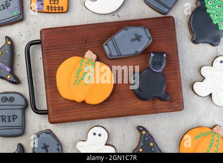 Pain d'épice d'Halloween, citrouille, pierre tombale, chat noir sur une planche sur une table en bois. Banque D'Images