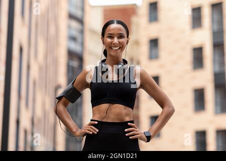 Athlétique jeune femme en Sportswear posant sur la rue de ville pendant l'entraînement en plein air Banque D'Images