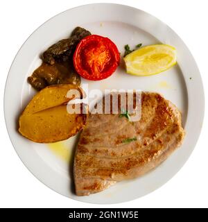 Steak de thon préparé servi avec du citron et de la tomate sur l'assiette Banque D'Images