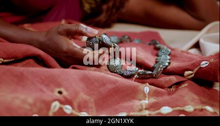 Main d'une femme africaine qui tient un collier traditionnel Banque D'Images