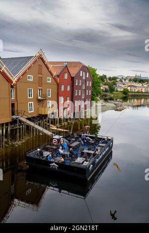 Pub, pub, restaurant Den Gode Nabo sur la terrasse de ponton en face des anciens entrepôts le long de Nidelva, Trondheim, Norvège Banque D'Images