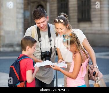 Voyageurs de famille heureux avec deux enfants avec carte à l'extérieur Banque D'Images