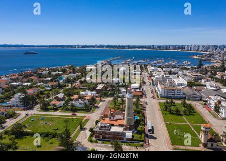 Vue aérienne du phare de Faro de Punta del Este avec la ville et le bateau de croisière d'expédition World Explorer (croisières nicko) au loin, Punta del Este, Banque D'Images