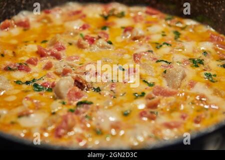 Le poisson-bar avec tomates fenouil et basilic est frit dans une casserole sur le poêle à gaz. Gros plan Banque D'Images