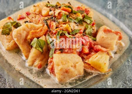 Poisson-basse avec tomates fenouil et basilic dans la sauce sur une assiette de verre. Gros plan Banque D'Images
